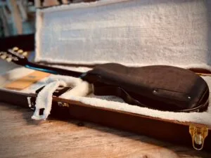 Highly gloss custom Fayland Guitar laying on its front in a custom made Fayland Guitars case for it.